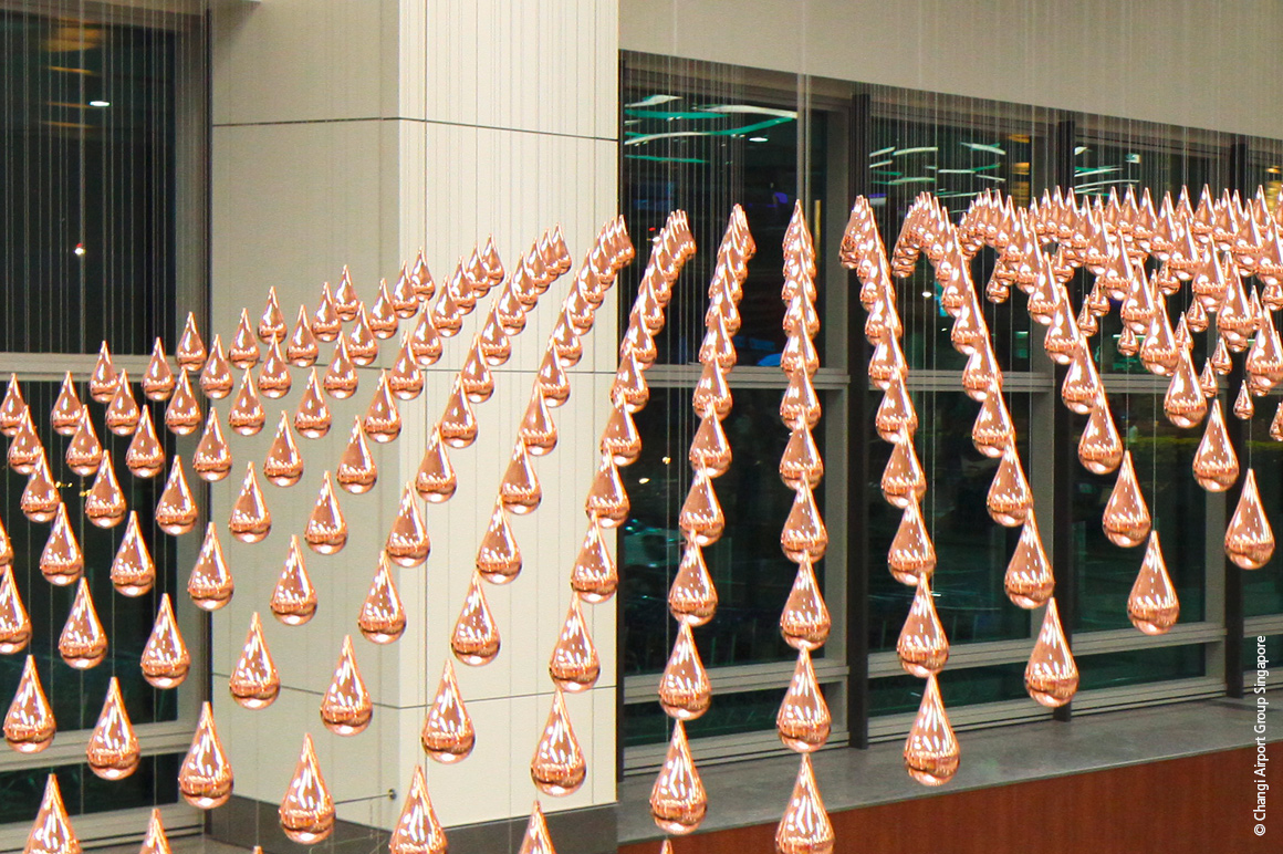 "Kinetic Rain" is a kinetic sculpture created at Singapore Changi Airport consisting of 1,216 glossy, copper-plated aluminum raindrops, which are moved in unison to form elaborate moving shapes. © Changi Airport Group Singapore