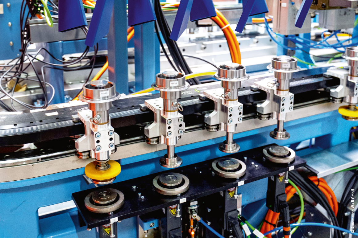 The bevel gears transported with the XTS movers are lifted via Beckhoff AM8000 servomotors, both for testing the internal gearing and for installation distance classification.