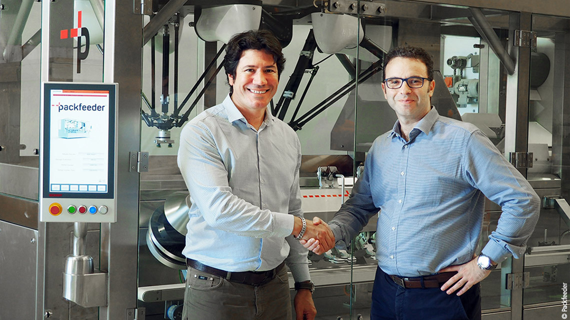 Packfeeder CEO Ferran Martínez (right) and Beckhoff Spain sales engineer Lluís Moreno (left) in front of the unscrambler machine and its easy-to-use multi-touch control panel in portrait orientation.