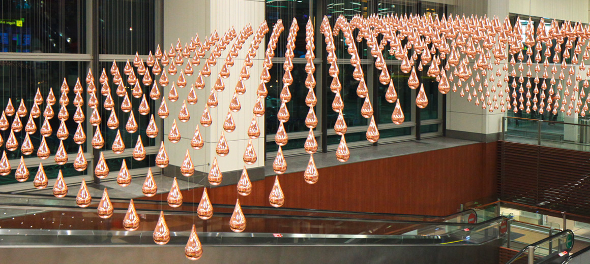 “Kinetic Rain“ is a moving sculpture consisting of 1,216 highly glossy, copper-plated aluminum raindrops, which was installed at Changi Airport in Singapore © Changi Airport Group Singapore